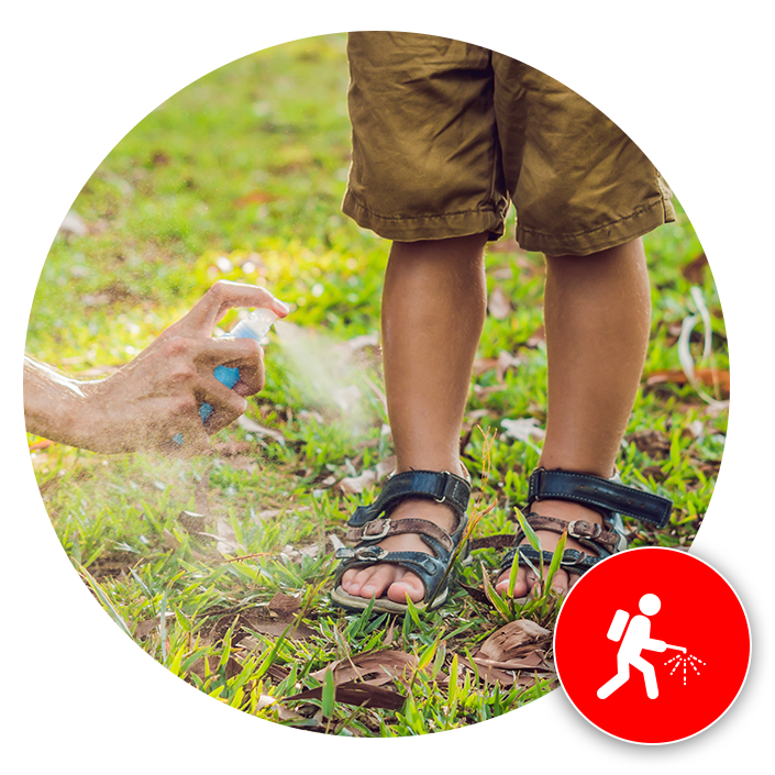 man spraying mosquito spray on child